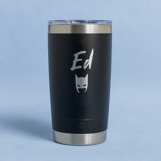 Black YETI tumbler with 'Ed' and a batman logo on a light blue background