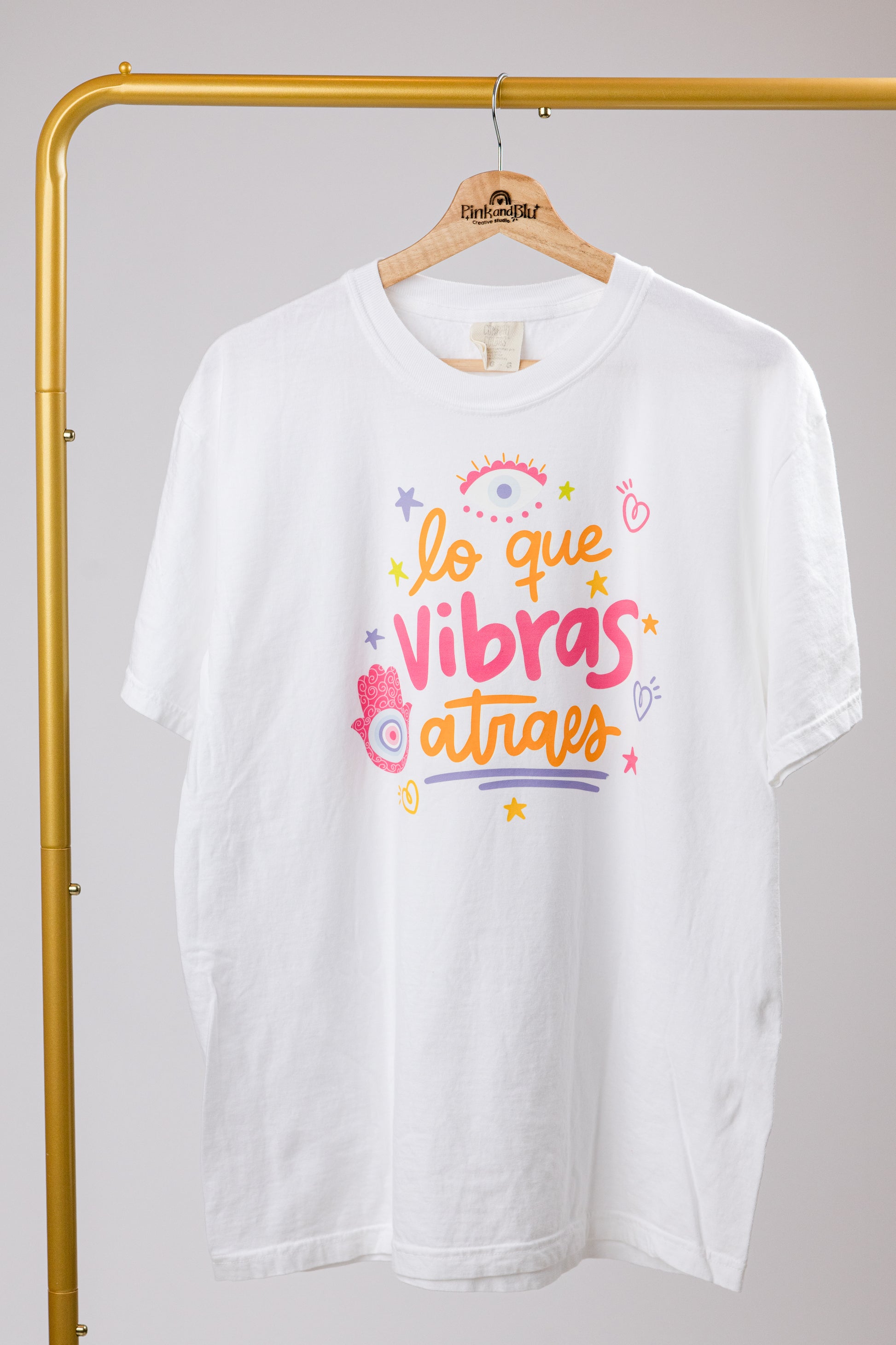white t-shirt with orange and pink text and graphics on a plain background
