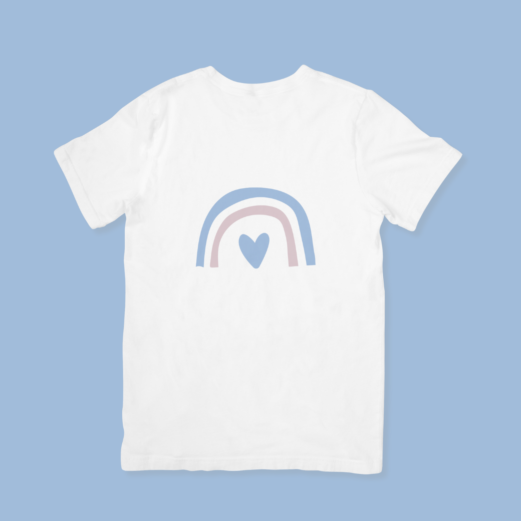 White t-shirt with a rainbow and heart design on a light blue background