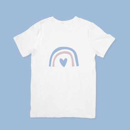White t-shirt with a rainbow and heart design on a light blue background