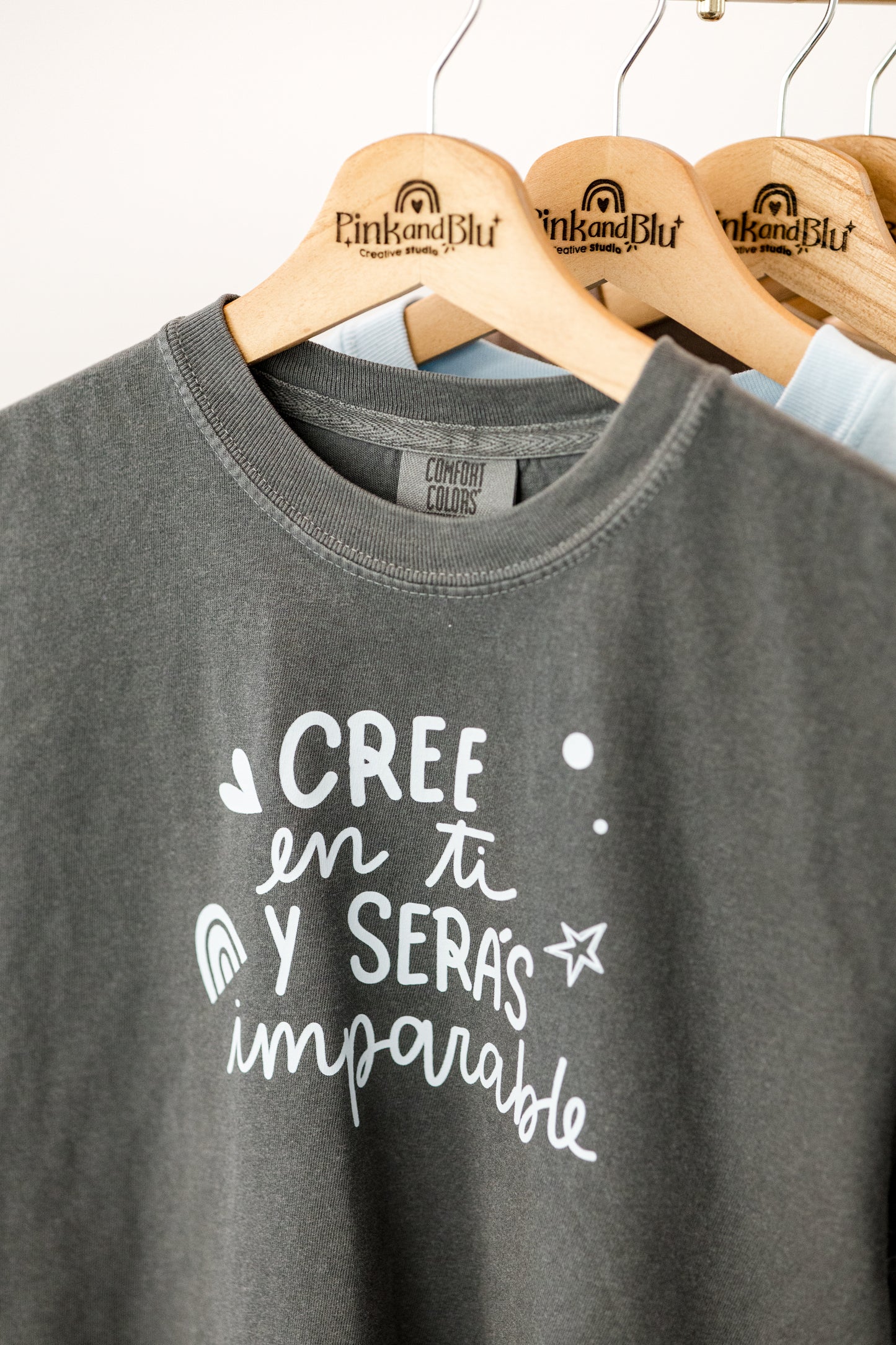 Gray t-shirt with white text on a hanger