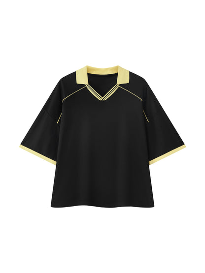 A black short-sleeve top with a V-neck collar and sleeve cuffs in pale yellow, featuring thin yellow piping details on the shoulders and collar, shown against a plain white background.