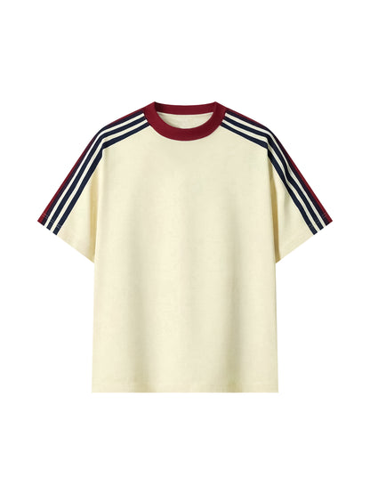 A cream-colored short-sleeve t-shirt with a dark red crew neck and navy and white striped shoulder details, shown against a plain white background.