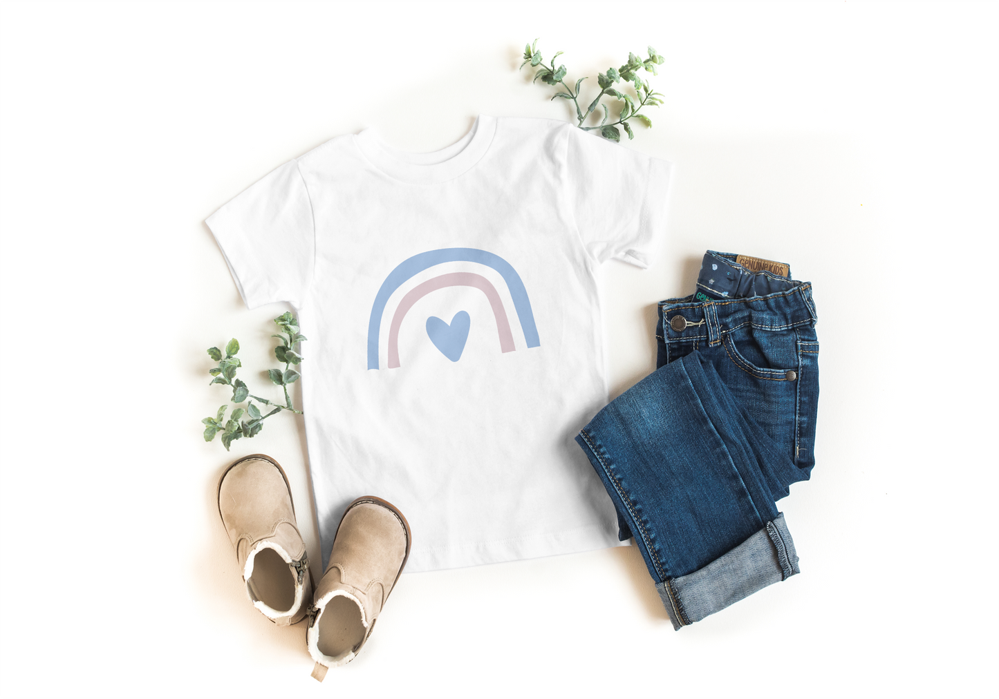 White t-shirt with rainbow and heart design, paired with jeans and shoes on a white background