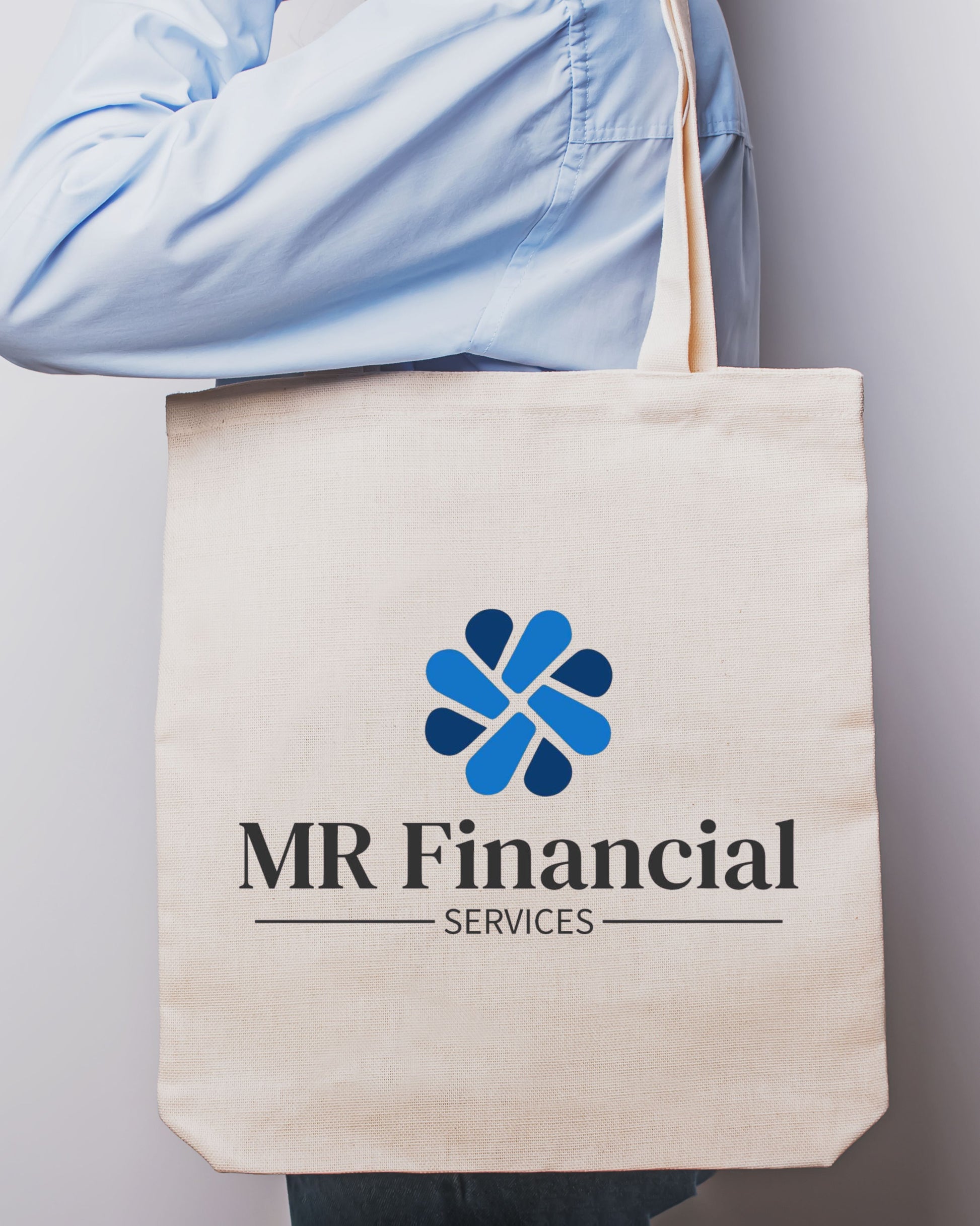 Tote bag with MR Financial Services logo held by a person wearing a light blue shirt.