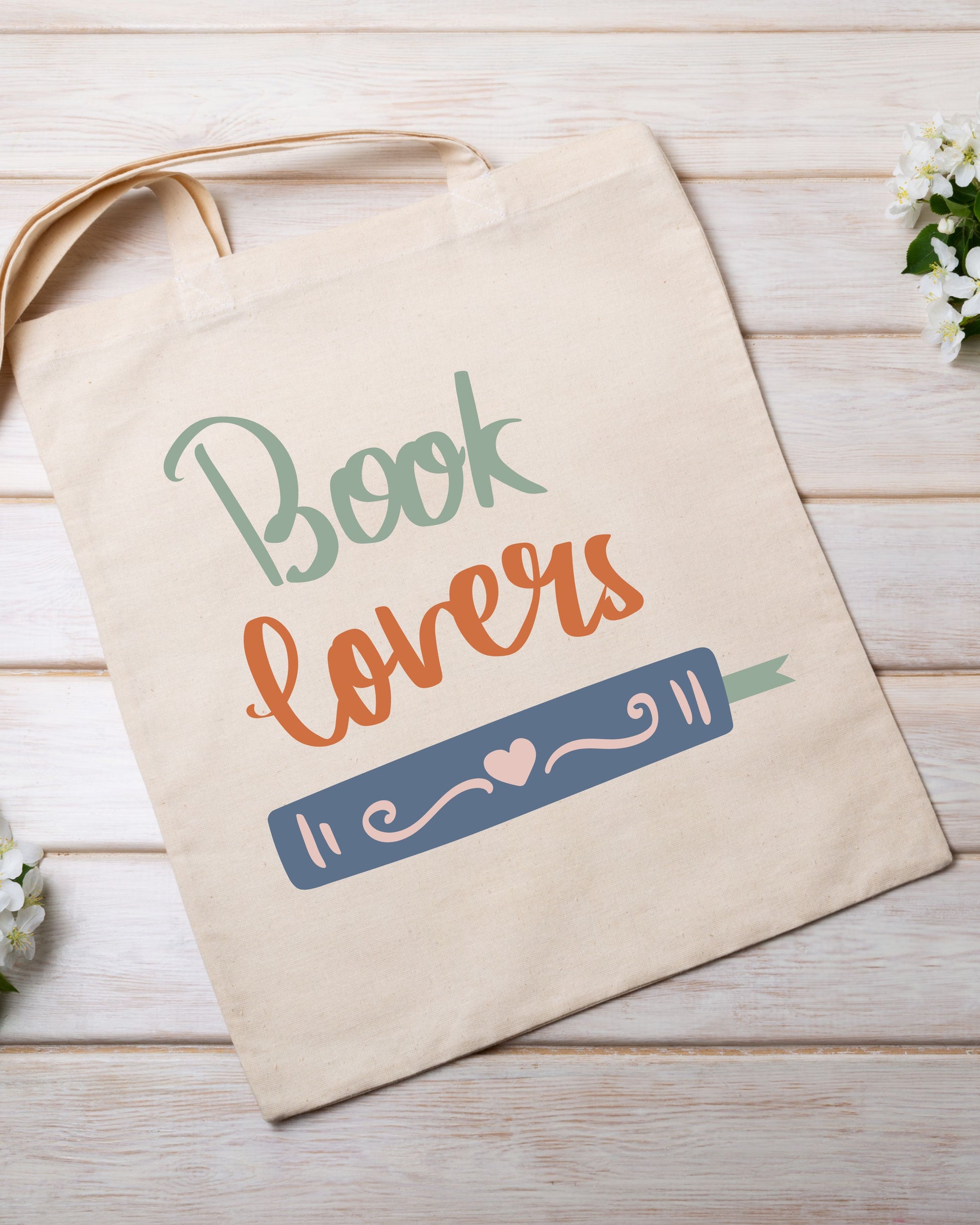 Beige tote bag with 'Book lovers' text and book illustration on a wooden surface